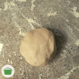 Imagem: Massa crua dos guiozas de legumes sobre uma bancada de pedra